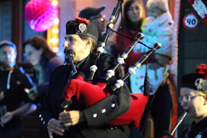 Dudelsackspieler im Kilt spielt vor Publikum auf einem Fest