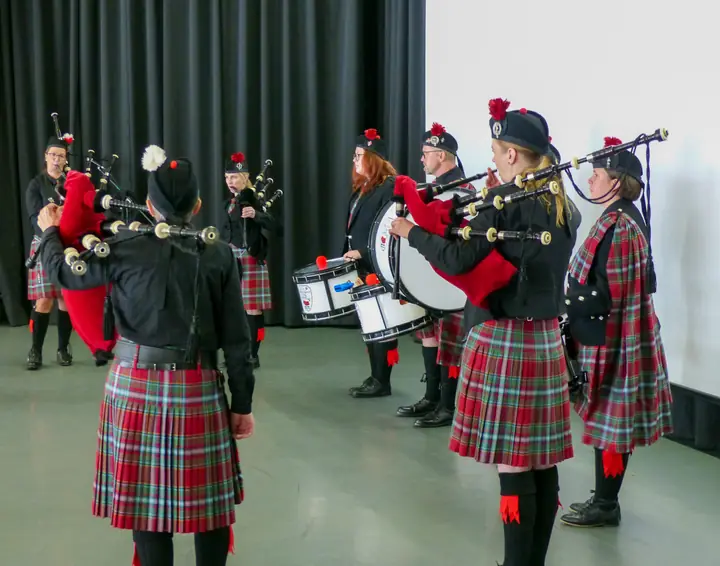 Piper und Drummer der Pipeband spielen im Kreis